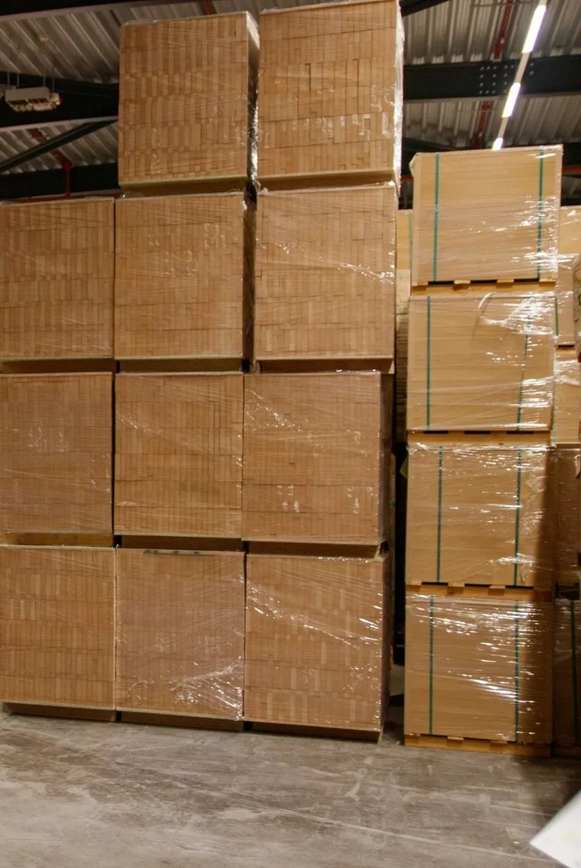Pallets of shrink-wrapped cartons stacked high in a warehouse